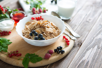Breakfast Cereal, Table setting. Healthy tasty breakfast multigrain wholewheat healthy cereals with strawberries, raspberries, black currants and red currants.