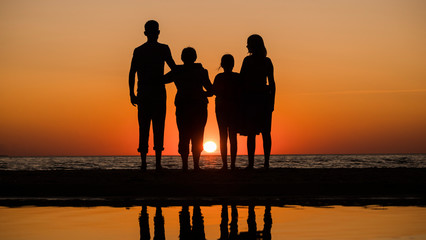 Friendly family meets sunrise over the sea