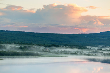 Fototapeta premium Sunset at a lake with fog in the woodland