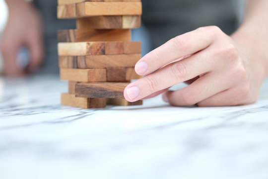 Man hand take one block from stack of wood blocks