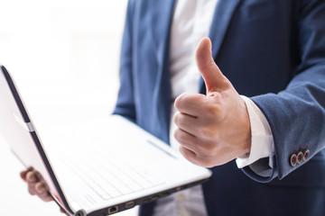 businessman with thumb raised making ok sign and laptop
