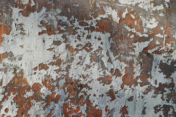 Texture of a grungy old cement stone wall with a paint peeling off. Rusty and gray colors background