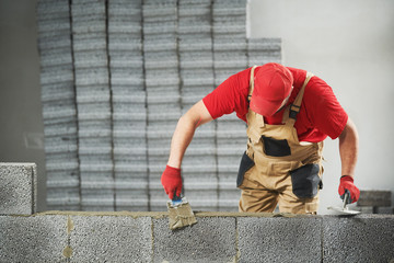 bricklayer builder working with ceramsite concrete blocks. Walling