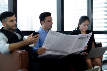 businessmans reading newspaper and talk with his team