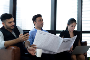 businessmans reading newspaper and talk with his team