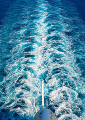 Trail on water surface behind of cruise ship