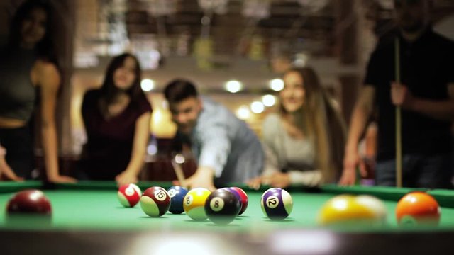 Many friends joyfully play billiards.