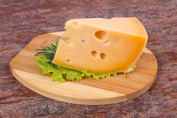 Maasdam cheese  in the board served salad leaves