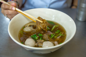 Eating clear stewed beef soup in Thailand, focus selective.