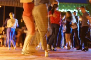 Defocused photography of dancing people. Night city street lifestyles concepts. 