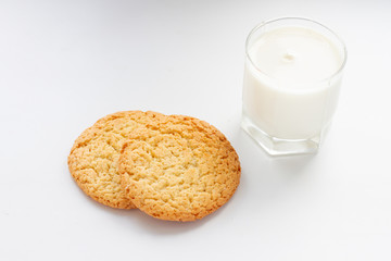 oatmeal cookies and a glass of milk on a white background