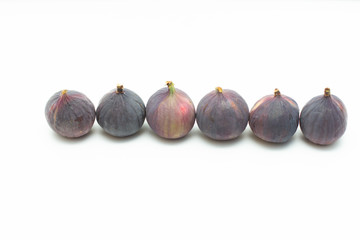 row of fresh figs on a white background