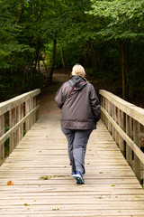 Old woman walkingover a bridge