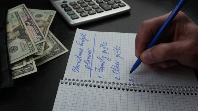 A man plans budget for Christmas. Monthly bills and expenses, household budgets and financial planning