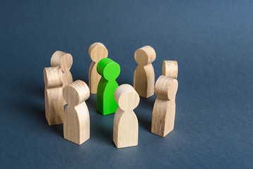 A green human figure is surrounded by a circle of people. Cooperation and collaboration....