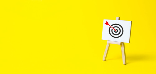 Sign stand with an arrow in the target on a yellow background. Hit exactly on center. Tactics of advertising targeting. advertise campaigns. Goal Achievement and Purposefulness - obrazy, fototapety, plakaty
