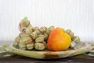 Ripe pear and decorative grapes on a plate