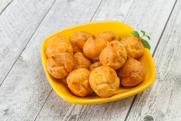 Sweet tasty profiteroles heap in the bowl