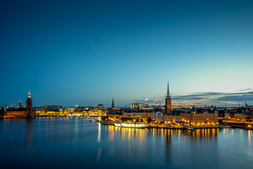 Fototapeta na wymiar A colorful sunrise over Stockholm with the lights reflecting on the calm water of the sea - 2