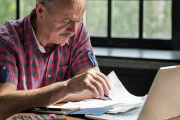 Serious mature hispanic man man checking home finance