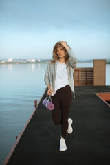 Girl on pier with yoga mat