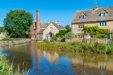 Fototapeta na wymiar LOWER SLAUGHTER, UK - SEPTEMBER 21, 2019: Lower Slaughter is a village in the Cotswold district of Gloucestershire. Built with a distinctive local yellow limestone, it sits on both banks of River Eye