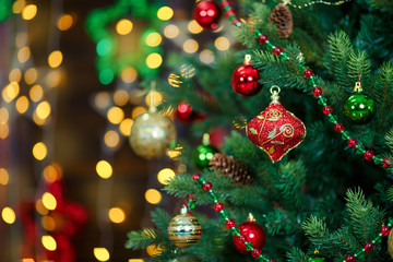 Multi-colored toys and beads on a New Year tree. Close-up