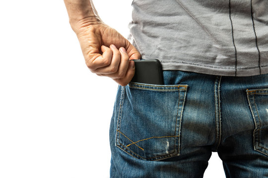 A Man Pulls A Smartphone Out Of The Back Pocket Of His Jeans