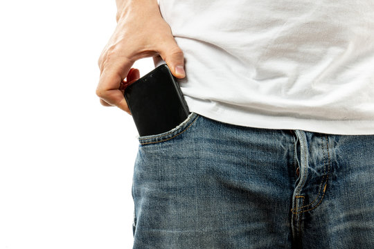 A man pulls a smartphone out of the front pocket of his jeans