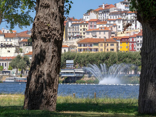 Coimbra, Portugal - August 03, 2019: Skyline of Coimbra city viewed from accross the Mondego river between the trees of the Mondego Park
