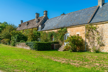 Fototapeta na wymiar Upper Slaughter village with characteristic Cotswolds houses built of distinctive local yellow limestone, Gloucestershire, UK