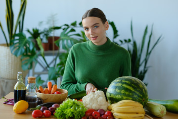 girl slices tomatoes to make a salad.