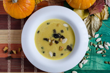 pumpkin soup in white plate wooden background autumn theme