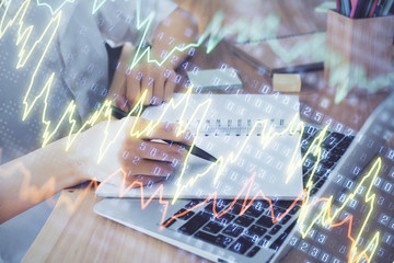 Financial charts displayed on woman's hand taking notes background. Concept of research. Double exposure