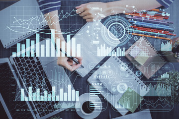 Financial forex graph drawn over hands taking notes background. Concept of research. Double exposure