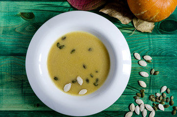 pumpkin soup in white plate wooden background autumn theme