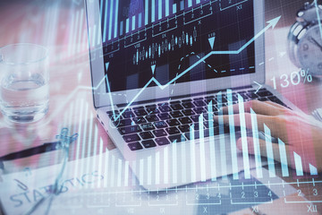 Multi exposure of market chart with man working on computer on background. Concept of financial analysis.