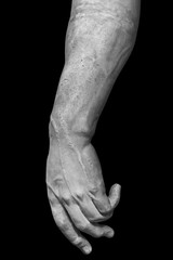 Stone statue detail of human hand isolated on black background by clipping path