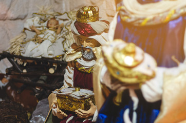 Christmas Nativity scene with The Holy Child, The Blessed Virgin Mary, Saint Joseph, ox and donkey in evening. Selective focus, noise effect