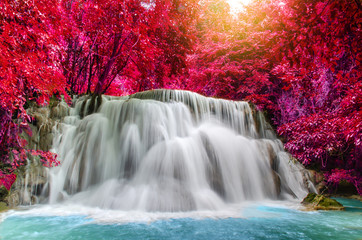 Travel to the beautiful waterfall in deep rainforest in autumn, soft water of the stream in the natural park at Huai Mae Khamin Waterfall in Kanchanaburi, Thailand. 