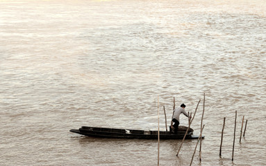Obraz premium Old fisherman on the boat in lake