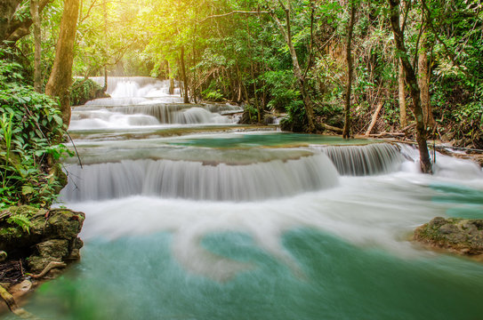 Travel to the beautiful waterfall in tropical rain forest, soft water of the stream in the natural park at Huai Mae Khamin Waterfall in Kanchanaburi, Thailand.