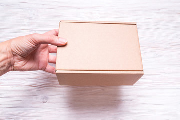 Cardboard box with handle on wooden background