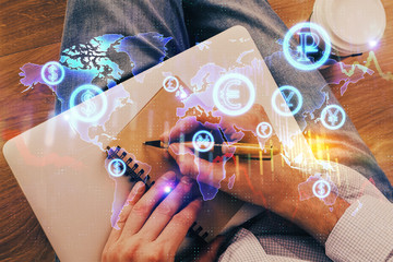 Double exposure of hands writing in notepad with stock market chart.