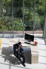Businessman sits and talking to smartphone..