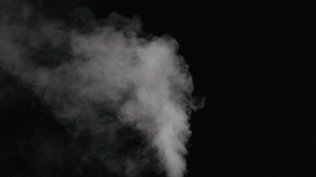 Slow motion water mist stream with wind effect over black background