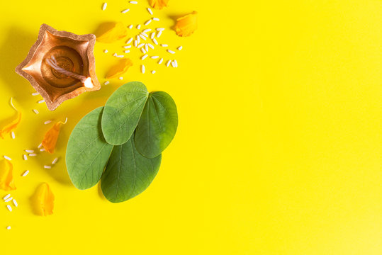 Happy Dussehra. Clay Diya lamps lit during Dussehra with yellow flowers,  green leaf and rice on yellow background. Dussehra Indian Festival concept.  Stock Photo | Adobe Stock