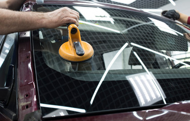 Automobile special workers glazier replacing windscreen windshield of car