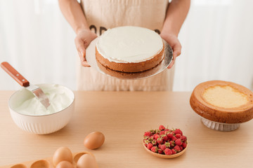 Male pastry chef holding sponge cake. The concept of homemade pastry, cooking cakes.