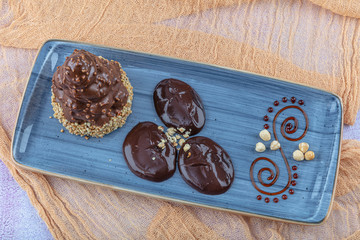 A piece of chocolate cake with hazelnut on the table, close-up.